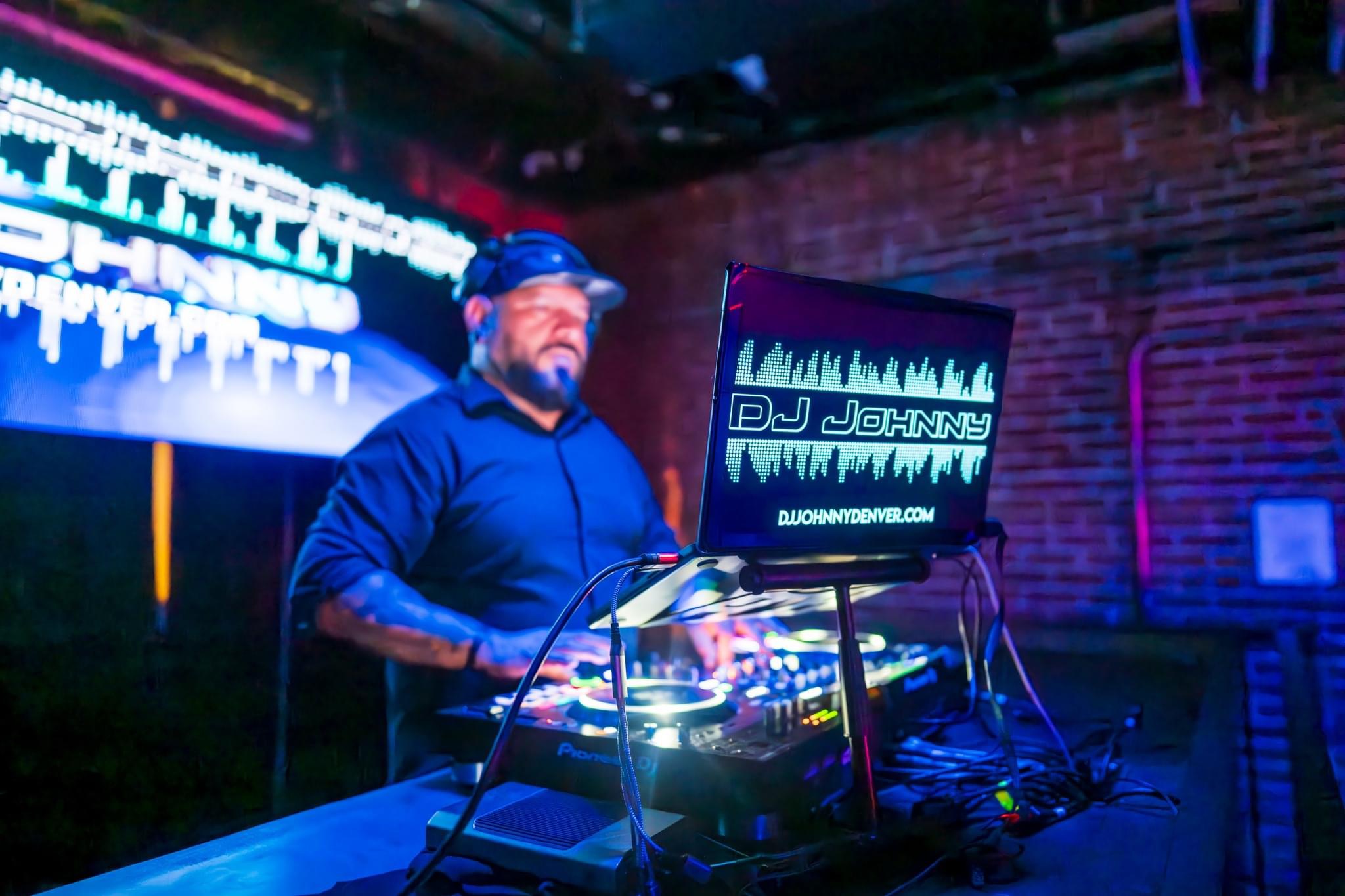 DJ Johnny mezclando en vivo junto a su pantalla LED de marca